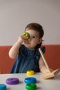 Baby girl playing with wooden colourful toy pyramid at home. Royalty Free Stock Photo