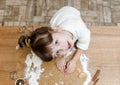 Cute baby girl is preparing gingerbread in kitchen. Funny little girl is having fun with dough and flour.View from above Royalty Free Stock Photo