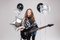 Cute baby girl rock star playing electric guitar and singing song surrounded by balloons Royalty Free Stock Photo