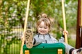 Cute baby girl on a seesaw swing at the playground.Cute baby girl on a swing seesaw. on the playground in the park Royalty Free Stock Photo