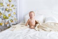 Cute baby girl sitting on bed at bedroom. Christmas.