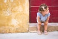 Cute baby girl sitting on the doorstep of a rural village home Royalty Free Stock Photo