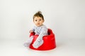 Cute baby girl sitting in a plastic seat Royalty Free Stock Photo