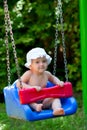 Cute baby girl sitting in a swing Royalty Free Stock Photo