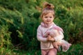 Cute baby girl with toy on green grass in summertime. Funny little kid on nature. Happy Childhood. Royalty Free Stock Photo