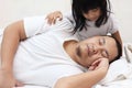 Cute baby girl wake her father up from sleep on the bed, morning hug and kiss from daughter Royalty Free Stock Photo