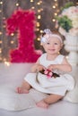 Cute baby girl 1-2 year old sitting on floor with pink balloons in room over white. Isolated. Birthday party. Celebration. Happy b Royalty Free Stock Photo