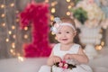 Cute baby girl 1-2 year old sitting on floor with pink balloons in room over white. Isolated. Birthday party. Celebration. Happy b Royalty Free Stock Photo