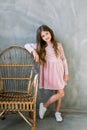 Cute baby girl 5-6 year old wearing stylish pink dress overgrey background. Looking at camera. Birthday party Royalty Free Stock Photo