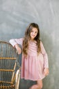 Cute baby girl 5-6 year old wearing stylish pink dress overgrey background. Looking at camera. Birthday party Royalty Free Stock Photo