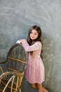 Cute baby girl 5-6 year old wearing stylish pink dress overgrey background. Looking at camera. Birthday party Royalty Free Stock Photo