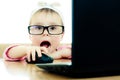 Cute baby with glasses looking into the laptop Royalty Free Stock Photo