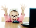 Cute baby with glasses looking into the laptop Royalty Free Stock Photo