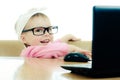 Cute baby with glasses looking into the laptop Royalty Free Stock Photo