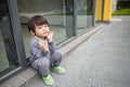 Cute baby in gray suit and green shoes standing and posing in front of glass door Royalty Free Stock Photo