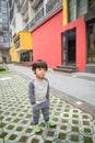 Cute baby in gray suit and green shoes standing and posing on trendy street Royalty Free Stock Photo