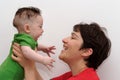 Cute baby held by his smiling mother profile view