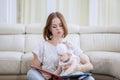 Cute baby and her mother reading a book at home Royalty Free Stock Photo