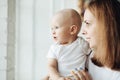 Cute baby and his mother by the window. Royalty Free Stock Photo