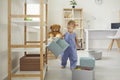 Cute baby in jumpsuit standing at home with empty box in hand Royalty Free Stock Photo