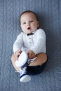 Cute baby lies and crawls on a white bed in a bright bedroom alone. Royalty Free Stock Photo