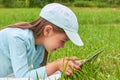 Cute baby lies on grass and plays computer Royalty Free Stock Photo