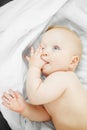 Cute baby lies on side with thumb in mouth Royalty Free Stock Photo