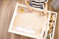 Cute baby little boy drawing smiley fun face on sand table therapy fine motor skills top view Royalty Free Stock Photo