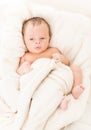 Cute baby lying on bed under blanket Royalty Free Stock Photo