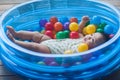 Cute baby lying in colorful toy balls and playing happily