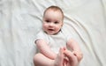 Cute baby lying and holding her legs, top view Royalty Free Stock Photo