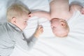 Cute baby and older brother interact while lying on the bed. Top view Royalty Free Stock Photo