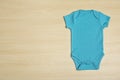 Cute baby onesie on wooden , top view. Space for text