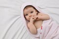 Cute little baby with pacifier in hooded towel after bathing on bed, top view Royalty Free Stock Photo
