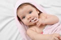 Cute little baby with pacifier in hooded towel after bathing on bed, top view Royalty Free Stock Photo