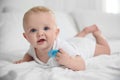 Cute baby with pacifier lying on bed Royalty Free Stock Photo