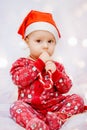 Cute baby in pajamas and santa claus hat on christmas background Royalty Free Stock Photo