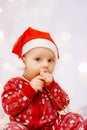 Cute baby in pajamas and santa claus hat on christmas background Royalty Free Stock Photo