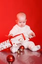 Cute baby playing with christmas presents and decorations Royalty Free Stock Photo