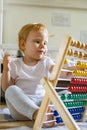 Cute baby playing colorful abacus with wooden beads kids toy enjoying self educational game Royalty Free Stock Photo