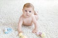 Cute baby girl playing with colorful pastel vintage rattle toy Royalty Free Stock Photo