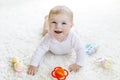 Cute baby girl playing with colorful pastel vintage rattle toy Royalty Free Stock Photo