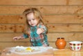 Cute baby playing with flour at wooden kitchen. Child cooking. Royalty Free Stock Photo