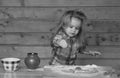 Cute baby playing with flour at wooden kitchen. Child cooking. Royalty Free Stock Photo