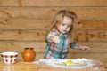 Cute baby playing with flour at wooden kitchen. Child cooking. Royalty Free Stock Photo