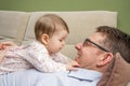 Cute baby playing with her happy father in a sofa Royalty Free Stock Photo