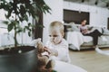 Cute Baby Playing while Mother Sitting on Couch Royalty Free Stock Photo