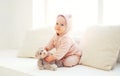 Cute baby playing with teddy bear toy at home in white room Royalty Free Stock Photo