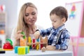 Cute baby playing with toys with teacher or mother indoors Royalty Free Stock Photo