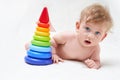 Cute baby plays with a multi-colored toy pyramid on a light background Royalty Free Stock Photo